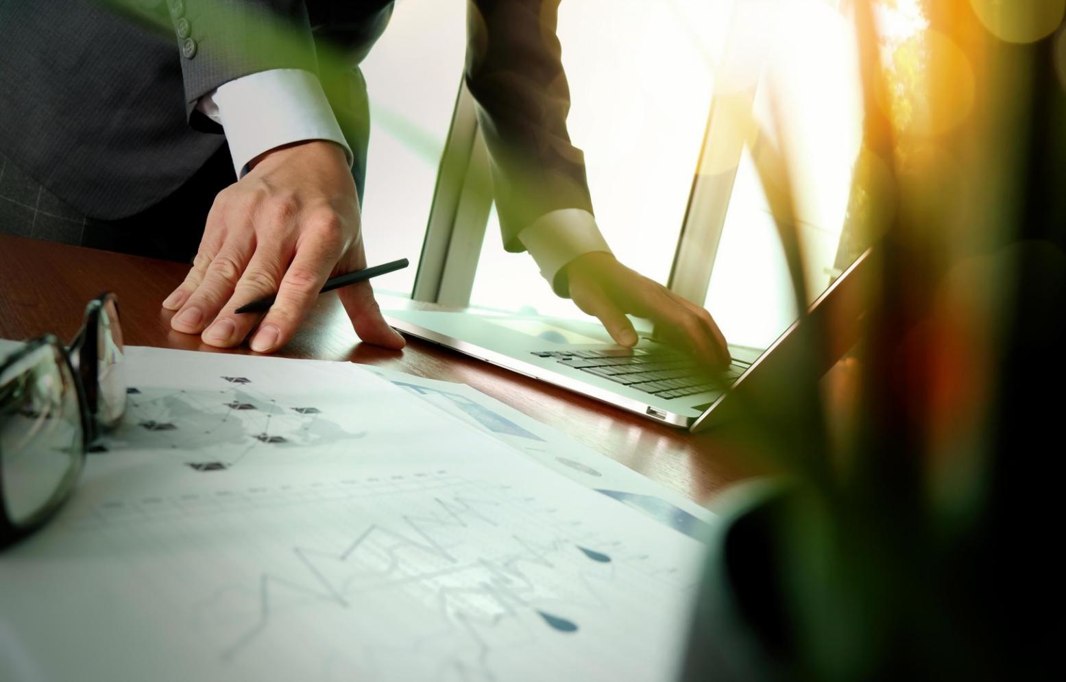 Students analyzing keyword research data on computer screens during practical workshop session